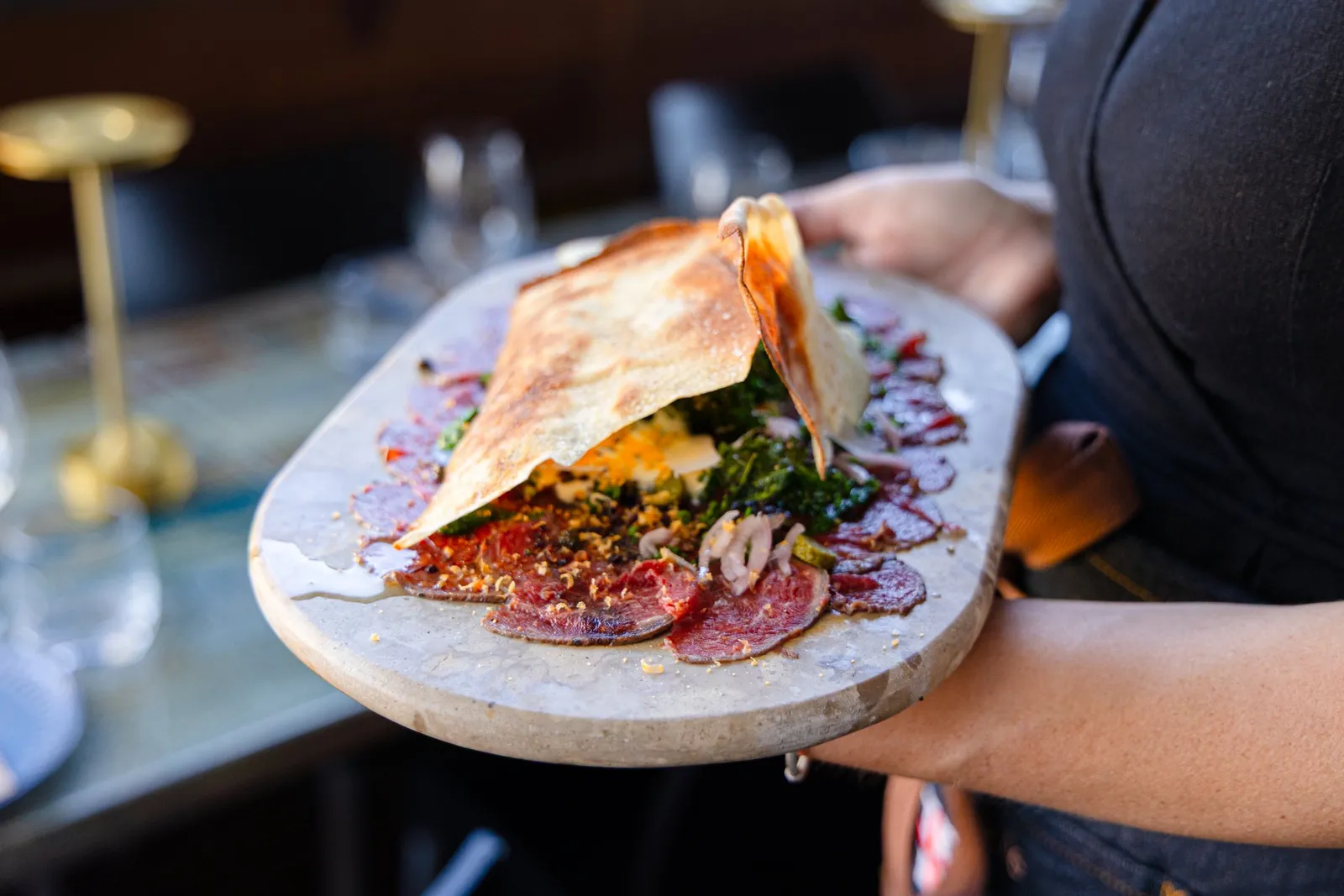 Black angus carpaccio carried to the table