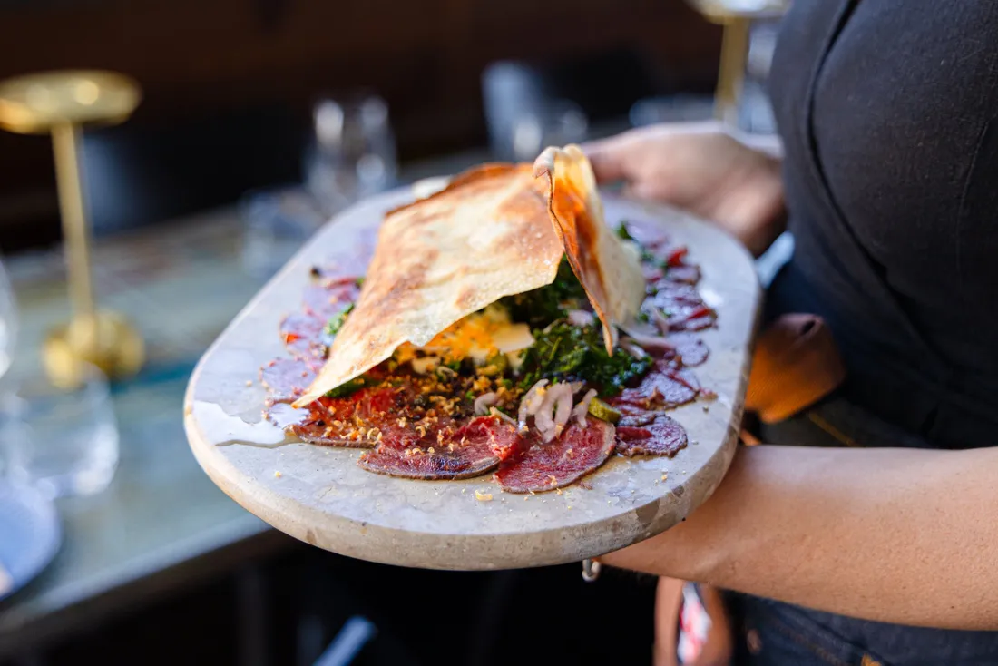 Black angus carpaccio carried to the table