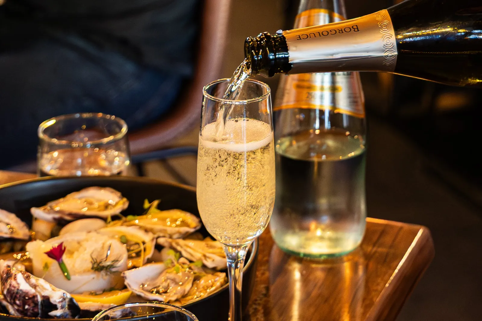 Sparkling poured beside a plate of oysters